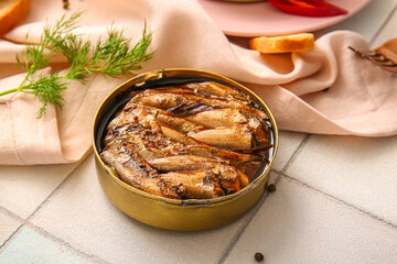 Canned smoked sprats with dill on white tile background