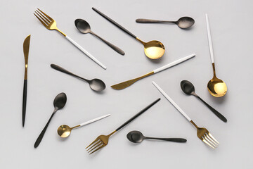 Set of different stainless steel cutlery on grey background