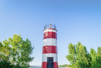 White-Red Lighthouse Surrounded by Deciduous Trees