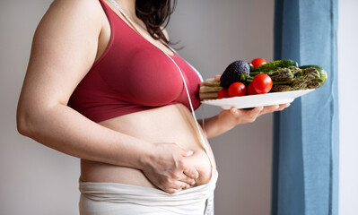 overweight woman in kitchen with measure tape centimeter on waist,holding belly fat with...