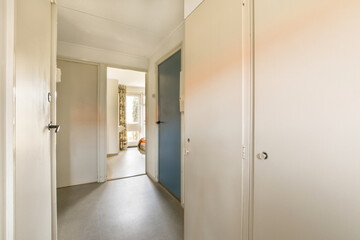 an empty hallway with blue doors and white trim on the walls, as seen from the doorway to the right