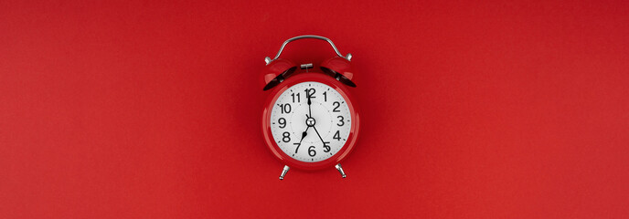 Red alarm clock on a red background. Top view.