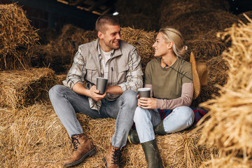 A lovely young couple relaxing among the haystacks