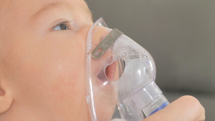 Doctor makes inhalation to a sick little baby. Health care and medicine concept at pediatrician...