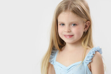 Studio headshot of beautiful 5 years old girl with blue eyes and long blonde hair