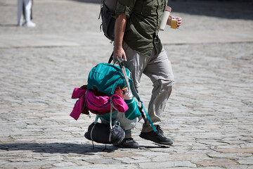 Pilgrims on the Camino de Santiago arrive at the Plaza del Obradoiro because they have finished their pilgrimage. A pilgrim carries his backpack in the Plaza del Obradoiro
