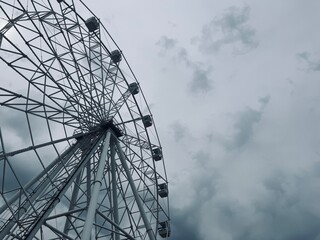 white Ferris wheel construction in the cloudy sky 