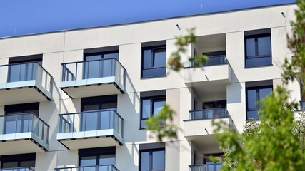 Eco architecture. Green tree and new apartment building. The harmony of nature and modernity. Modern residential building with new apartments in a green residential area. 
