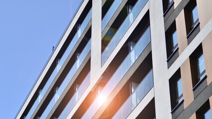 Apartment building with bright facades. Modern minimalist architecture with lots of square glass windows and balconies.