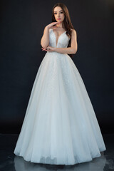 Fototapeta premium Beautiful bride in wedding dress on black background