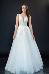 Fototapeta premium Beautiful bride in wedding dress on black background