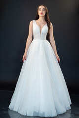 Fototapeta na wymiar Beautiful bride in wedding dress on black background