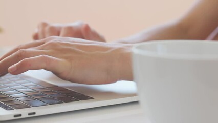 Photographer's workplace, laptop and camera lenses on a white table, photographer concept with digital camera, hands on keyboard close up