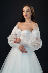 Beautiful bride in wedding dress on black background