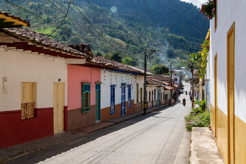Fototapeta na wymiar Streets of a town in Colombia, where you can see people walking through colored houses. Town in the mountains of Latin America.