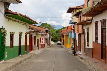 Streets of a town in Colombia, where you can see people walking through colored houses. Town in the...