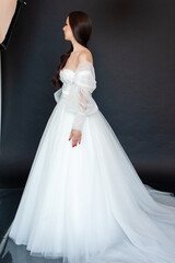Fototapeta premium Beautiful bride in wedding dress on black background
