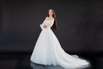  Beautiful fashion bride posing in wedding dress on black background 