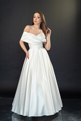 Fototapeta premium Beautiful fashion bride in wedding dress posing ob black background