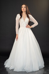 Fototapeta na wymiar Beautiful fashion bride in wedding dress posing ob black background
