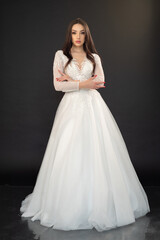 Fototapeta premium Beautiful fashion bride in wedding dress posing ob black background
