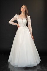 Fototapeta premium Beautiful fashion bride in wedding dress posing ob black background
