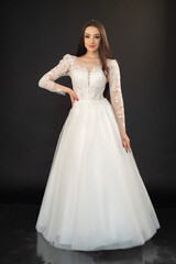 Fototapeta premium Beautiful fashion bride in wedding dress posing ob black background