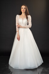 Fototapeta na wymiar Beautiful fashion bride in wedding dress posing ob black background