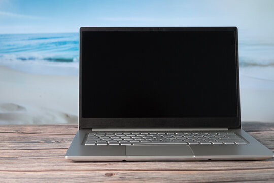 Laptop on vacation with out-of-focus beach © Gabriela