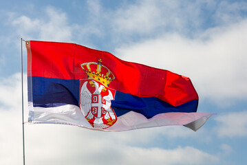 Serbian flag flying against the blue sky
