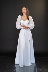 Fototapeta na wymiar Stylish beautiful woman bride in wedding dress on black background