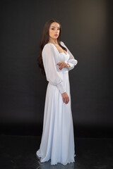 Fototapeta na wymiar Stylish beautiful woman bride in wedding dress on black background