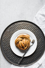 top view of Swedish cinnamon buns on a white plate, cinnamon twists on a plate, top view of homemade Kanelbullar