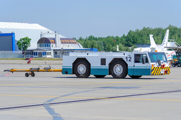 Aviation pushback tug on the airport apron. Low-profile tractor for moving aircraft along the...