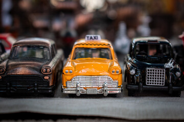 Modelo miniatura de un taxi amarillo y otros vehículos