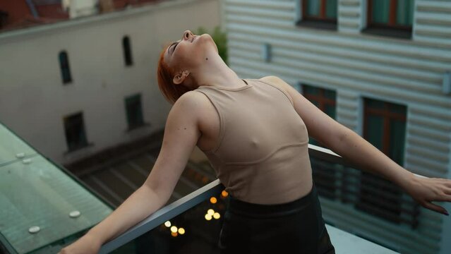 Elevated Happiness: Happy Young Woman Smiling and Striking a Pose on a Rooftop Terrace at Dus