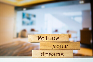Wooden blocks with words 'Follow your dreams'.