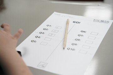 A kid is solving math problems on a paper. a child is doing math using mental arithmetic and writing on a paper.