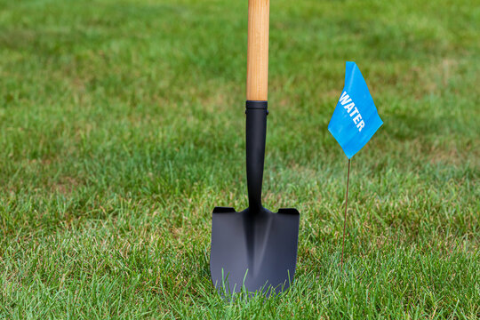 Water utility warning flag with shovel. Notify utility locate company for underground utilities, call before you dig and digging safety concept