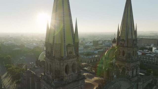 Dramatic close up view of Guadalajara Cathedral in Mexico. Architecture design details in neo gothic style highlighted by bright golden sun light. Drone flying close to decorated church in latin city