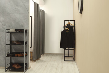 Dressing room with clothing rack in fashion store. Stylish design