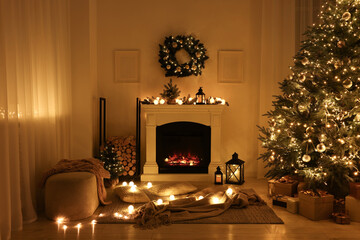 Beautiful living room interior with burning fireplace and Christmas tree in evening