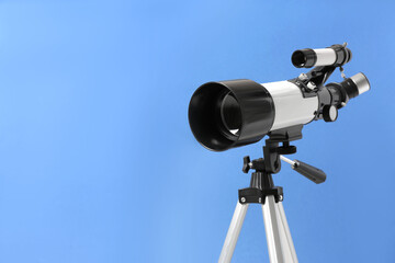 Tripod with modern telescope on blue background, closeup. Space for text
