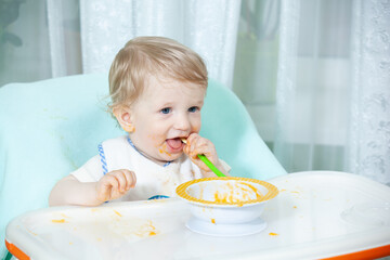 smiling baby eating food on kitchen