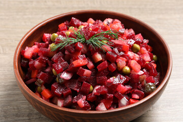 Bowl of delicious fresh vinaigrette salad on wooden table, closeup