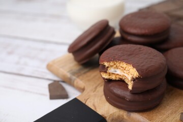 Tasty choco pies on white wooden table, closeup. Space for text