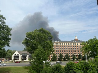 Black smoke from a fire billows behind a brick structure