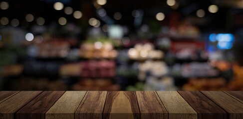 Empty wooden table top in front of abstract blur restaurant background.