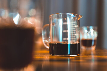 Professional hipster barista making drip brewing, filtered coffee or pour over coffee with hot water and filter paper in coffee shop cafe, black vintage tone of fresh caffeine aroma beverage