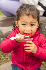 eating delicious jelly latin girl with collected hair wear casual clothes, food utensils, enjoying sweet dessert, lifestyle and portrait